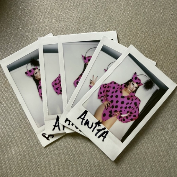 A stack of Anita Piss BBC Socials polaroids, each signed by hand in black marker
